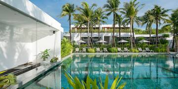 a pool with palm trees and a building