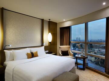 a hotel room with a bed and chairs