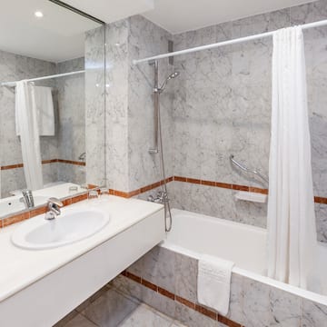 a bathroom with marble walls and a shower curtain