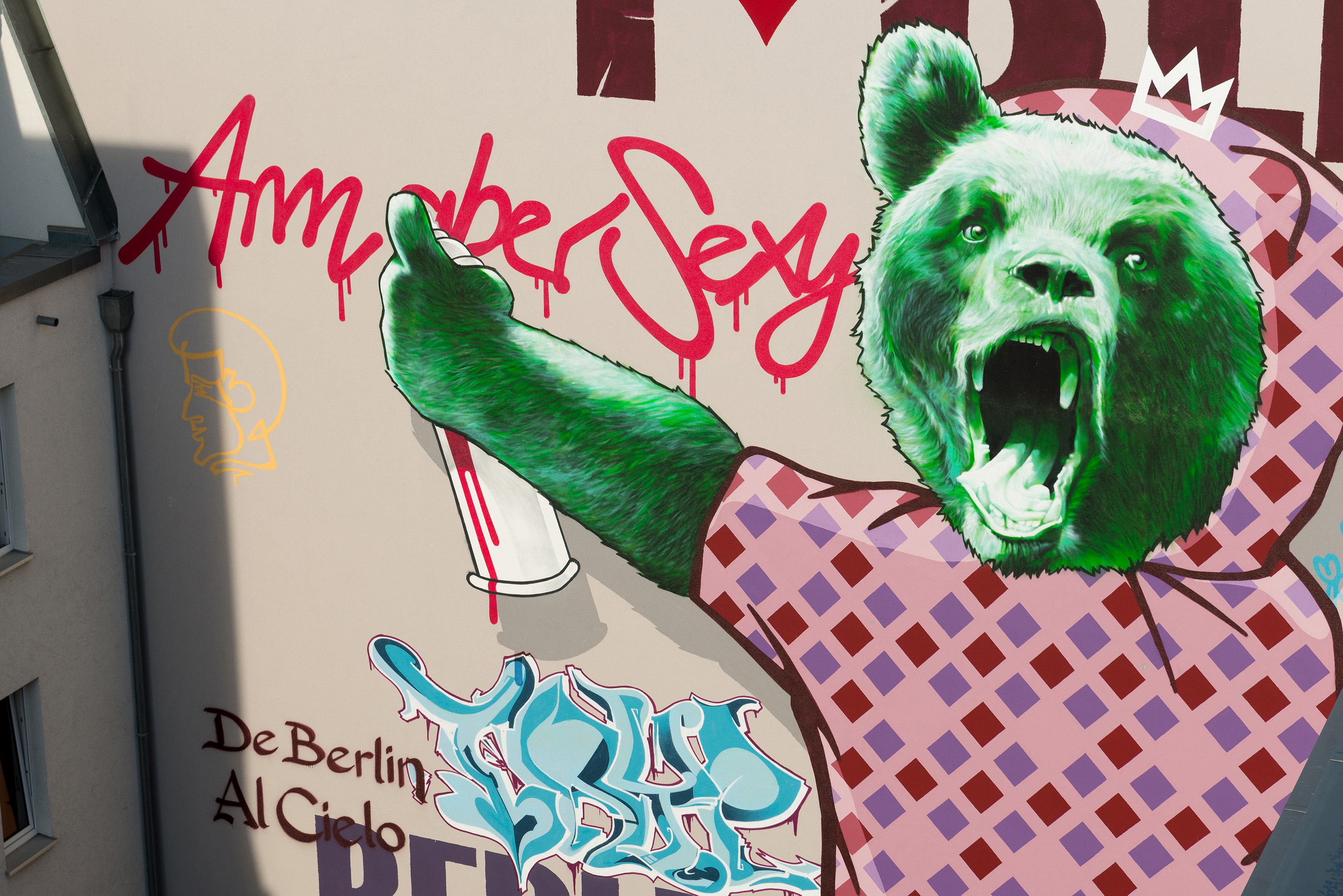 Green bear graffiti mural with crown, holding spray can, 'Amaber Sexy' text.