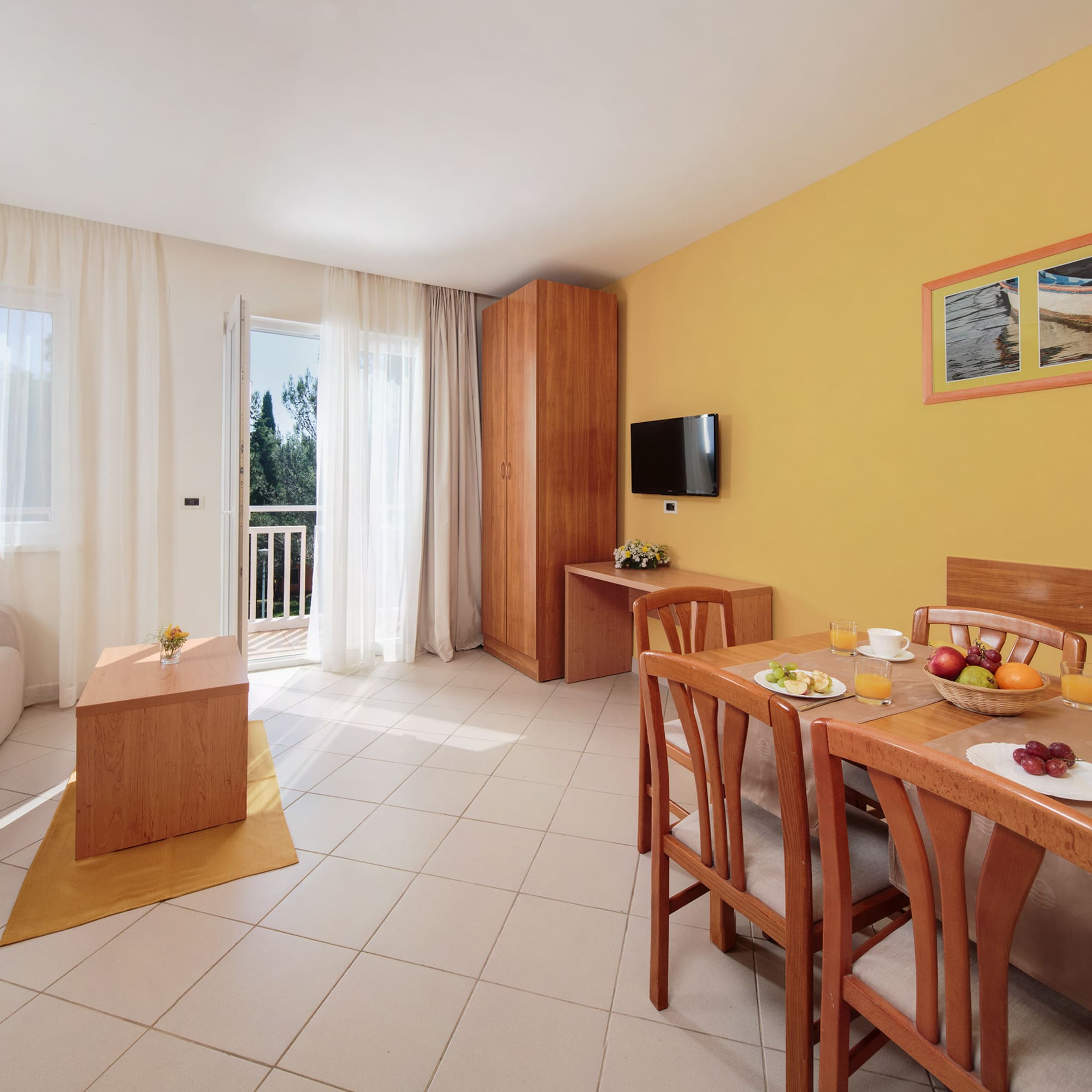 a room with a table and chairs and a television