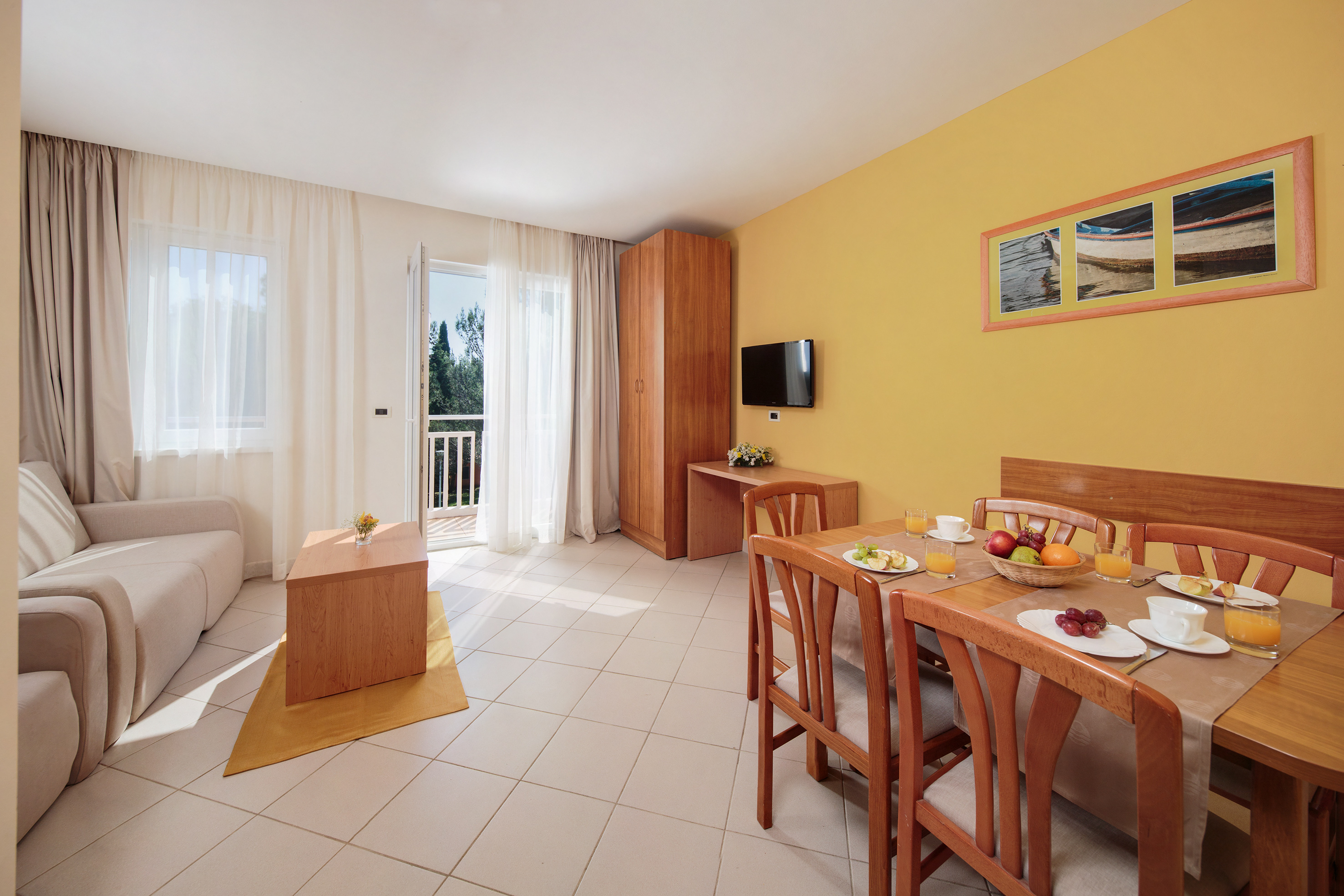 a room with a table and chairs and a television
