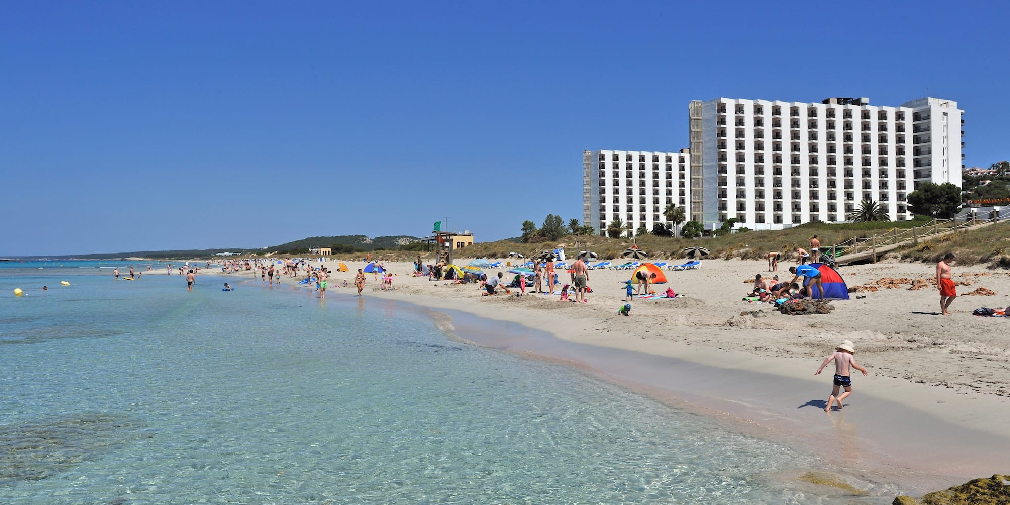 a beach with people and water with Clearwater Beach in the background