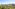 Coastal city panorama: green trees, urban buildings, and clear blue sea