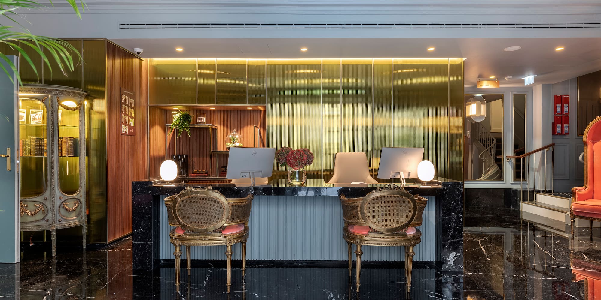 a lobby with a black marble floor and gold walls