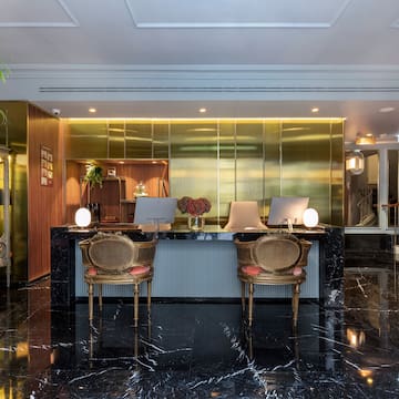 a lobby with a black marble floor and gold walls