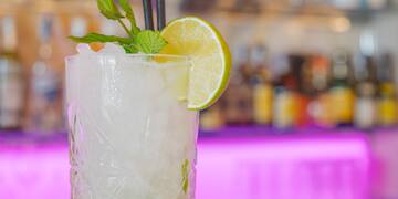 a glass with a drink and a slice of lime and mint