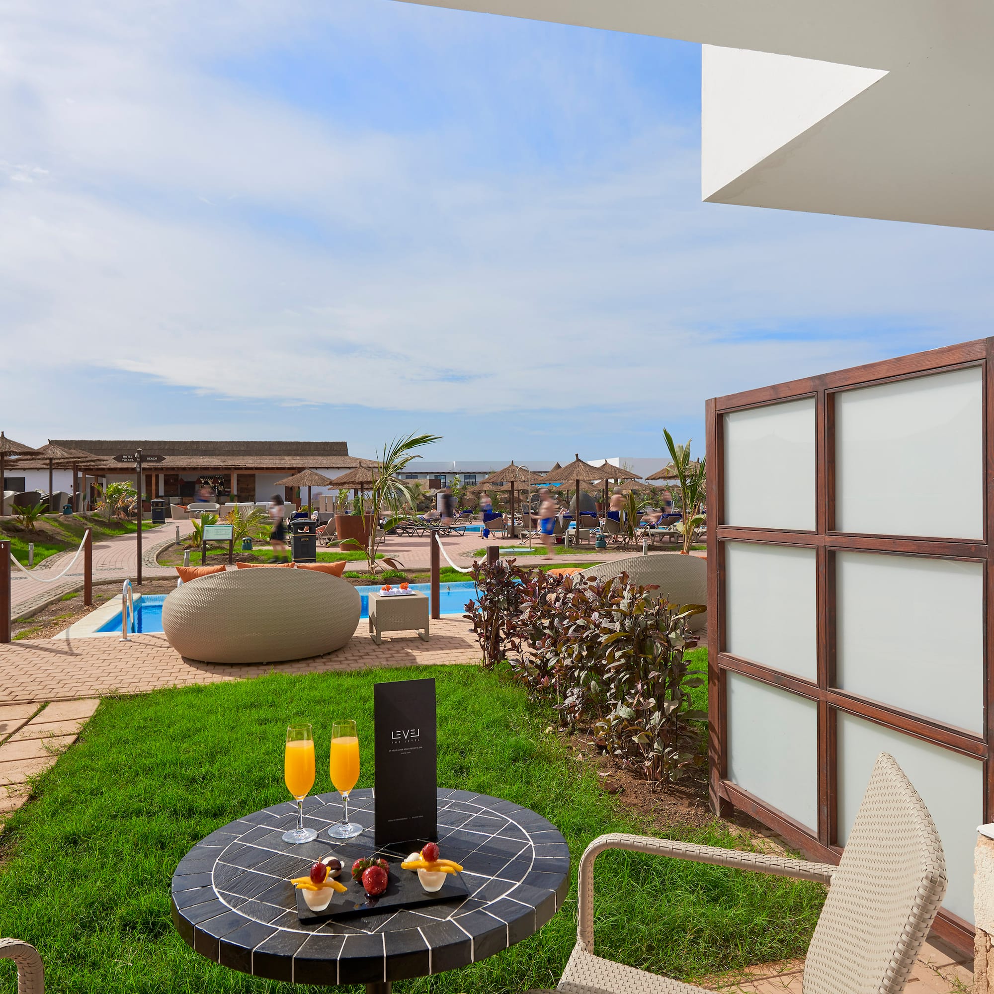 a table with drinks on it and a pool in the background