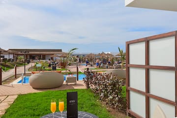 a table with drinks on it and a pool in the background