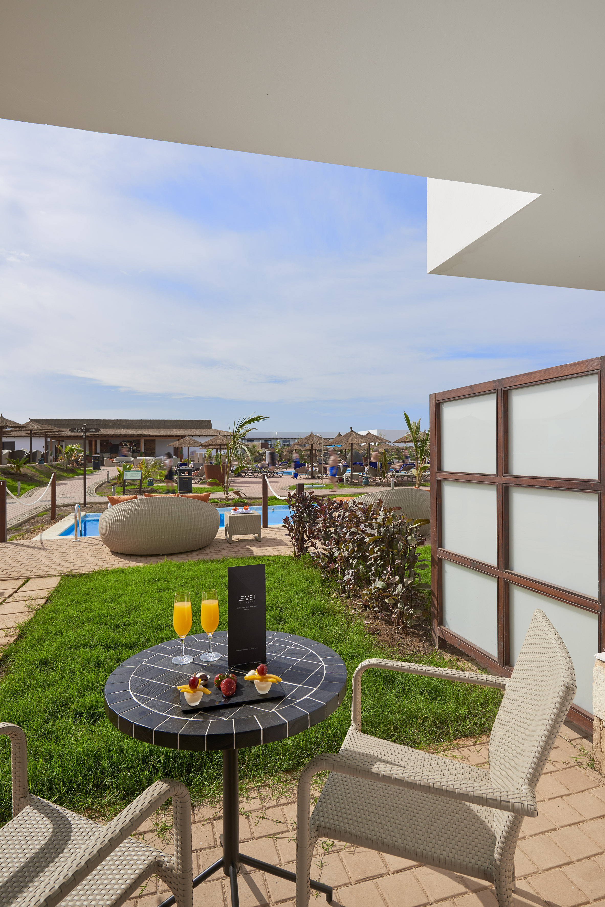 a table with drinks on it and a pool in the background