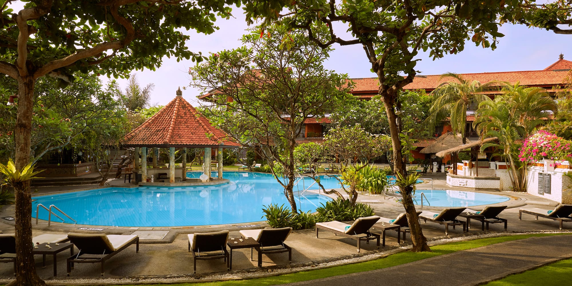 a pool with lounge chairs and a gazebo