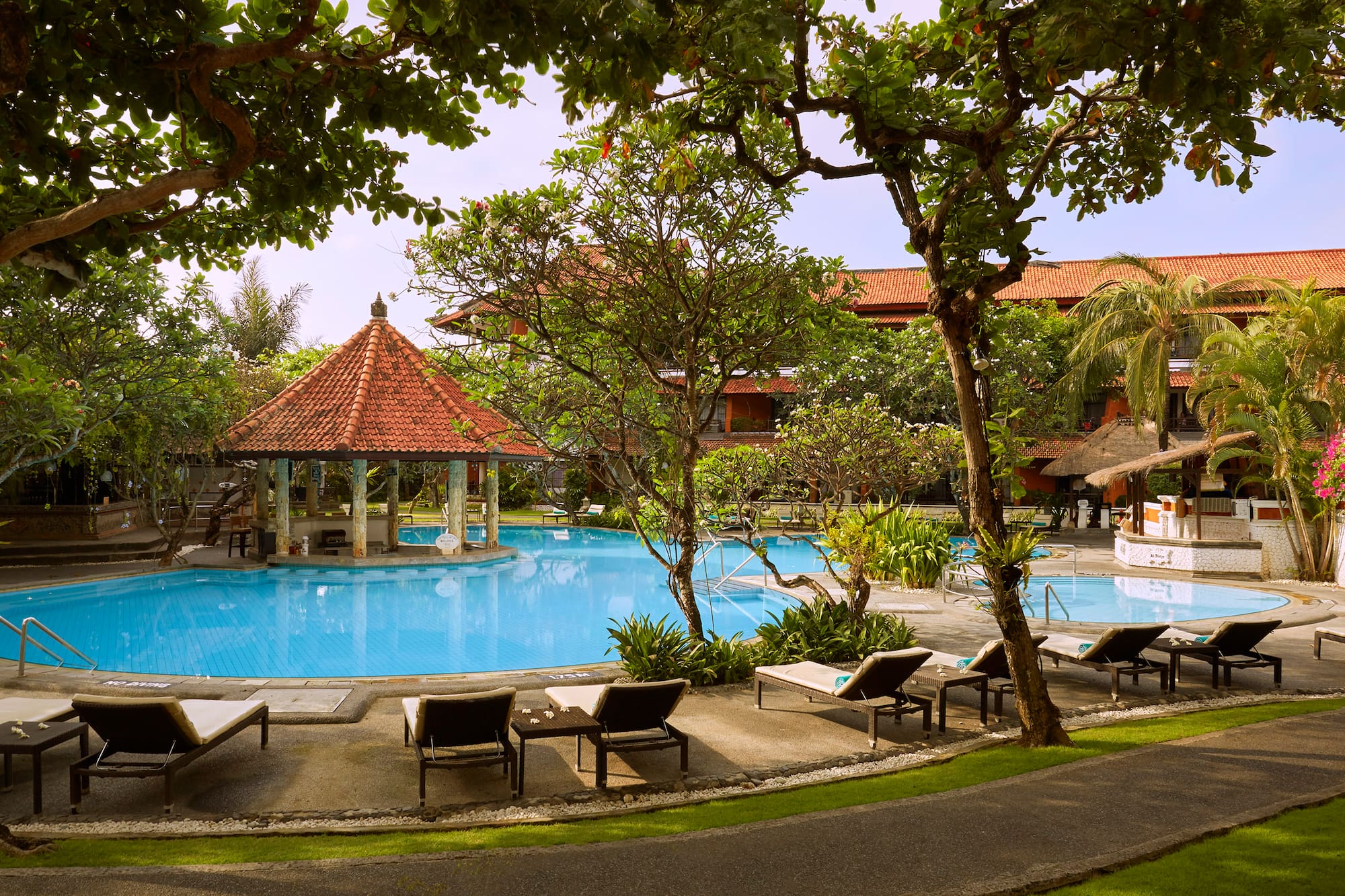 a pool with lounge chairs and a gazebo