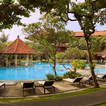 a pool with lounge chairs and a gazebo