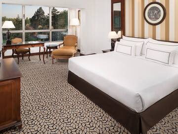 a hotel room with a bed and chairs