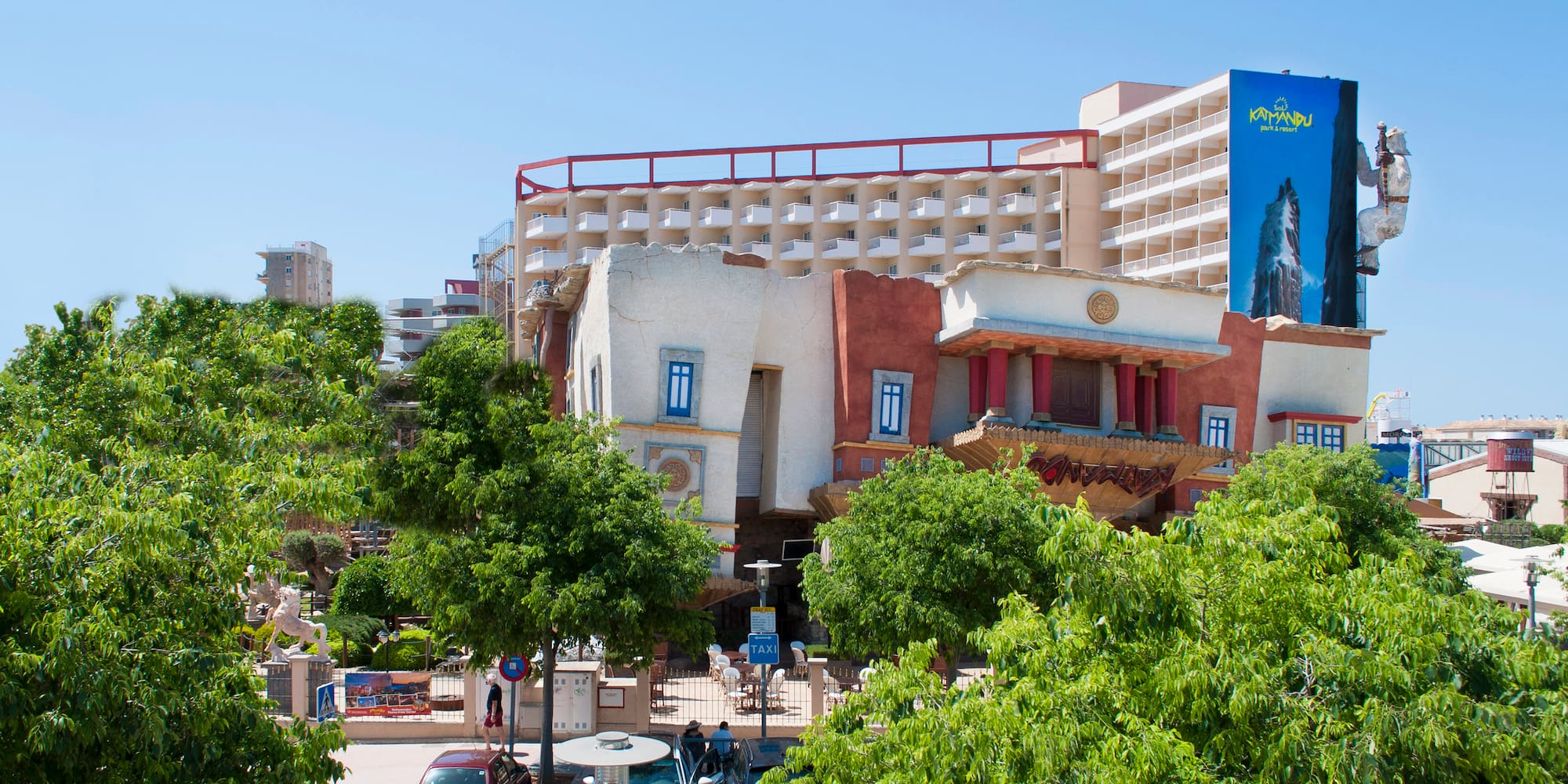 a building with trees and cars in front of it