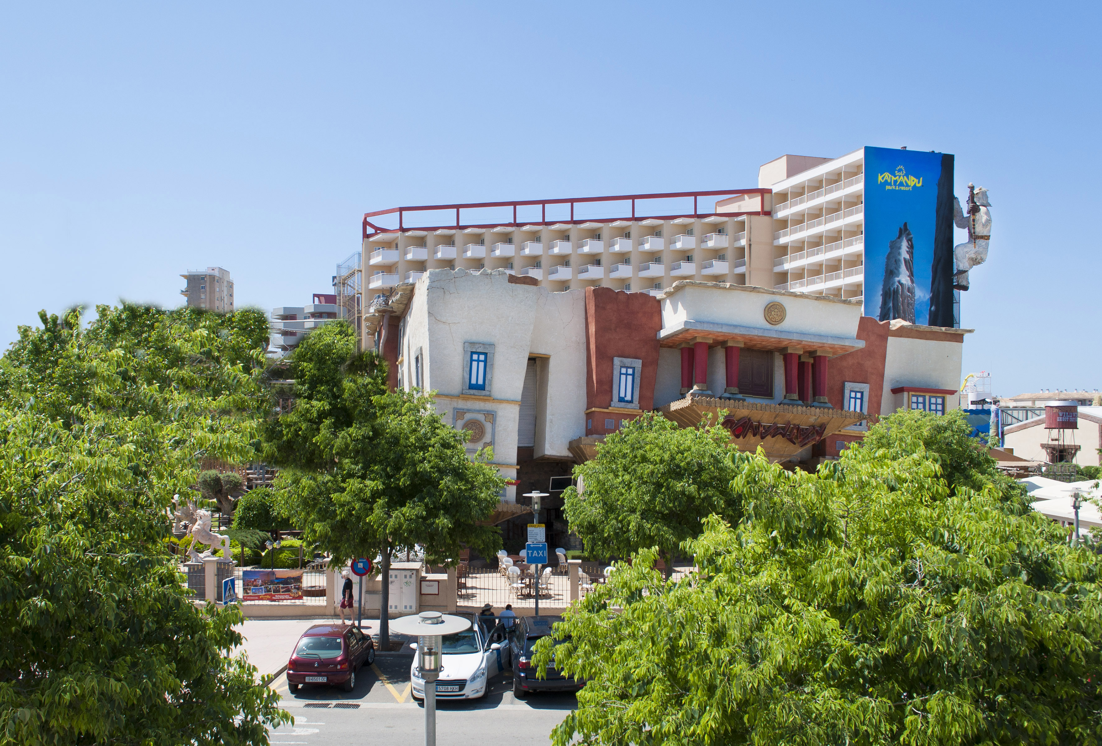 a building with trees and cars in front of it
