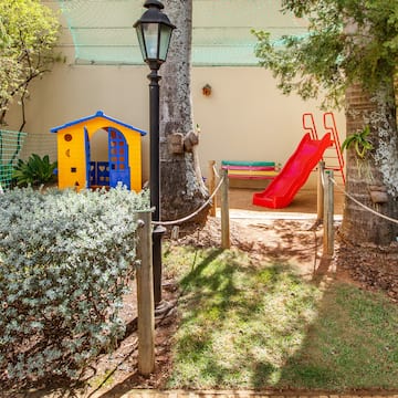 a playground with a slide and a tree