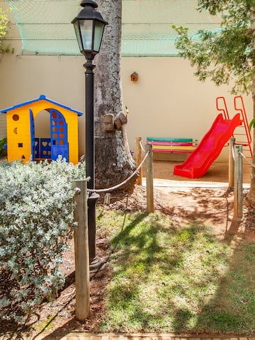 a playground with a slide and a tree