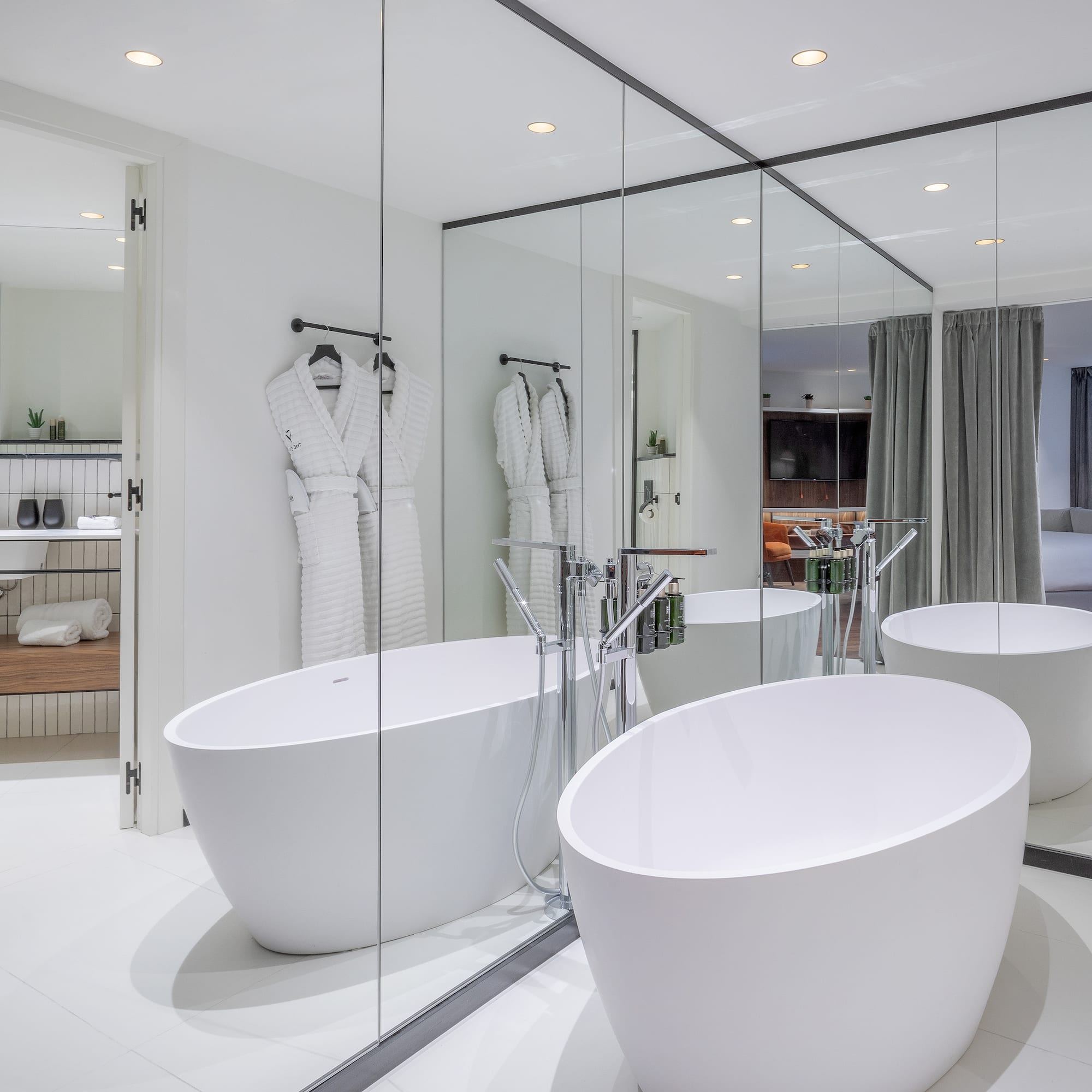 a bathroom with large tubs and mirrors