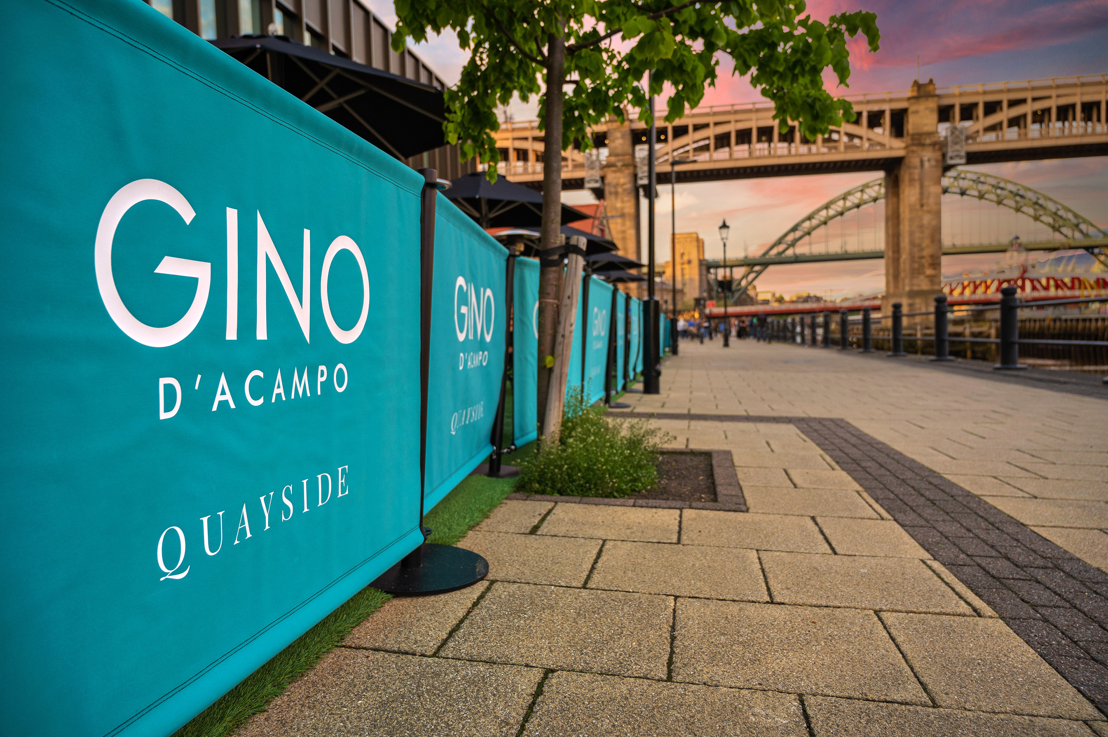 Gino D'Acampo Quayside restaurant banners, Newcastle Tyne Bridge at sunset.