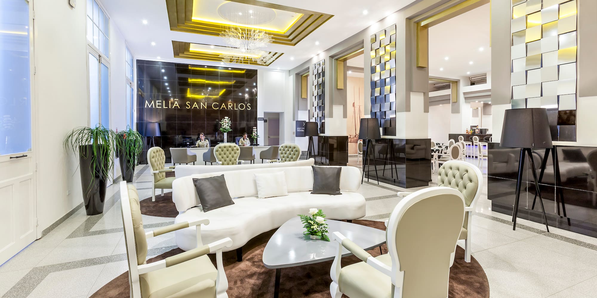 a lobby with a white couch and chairs