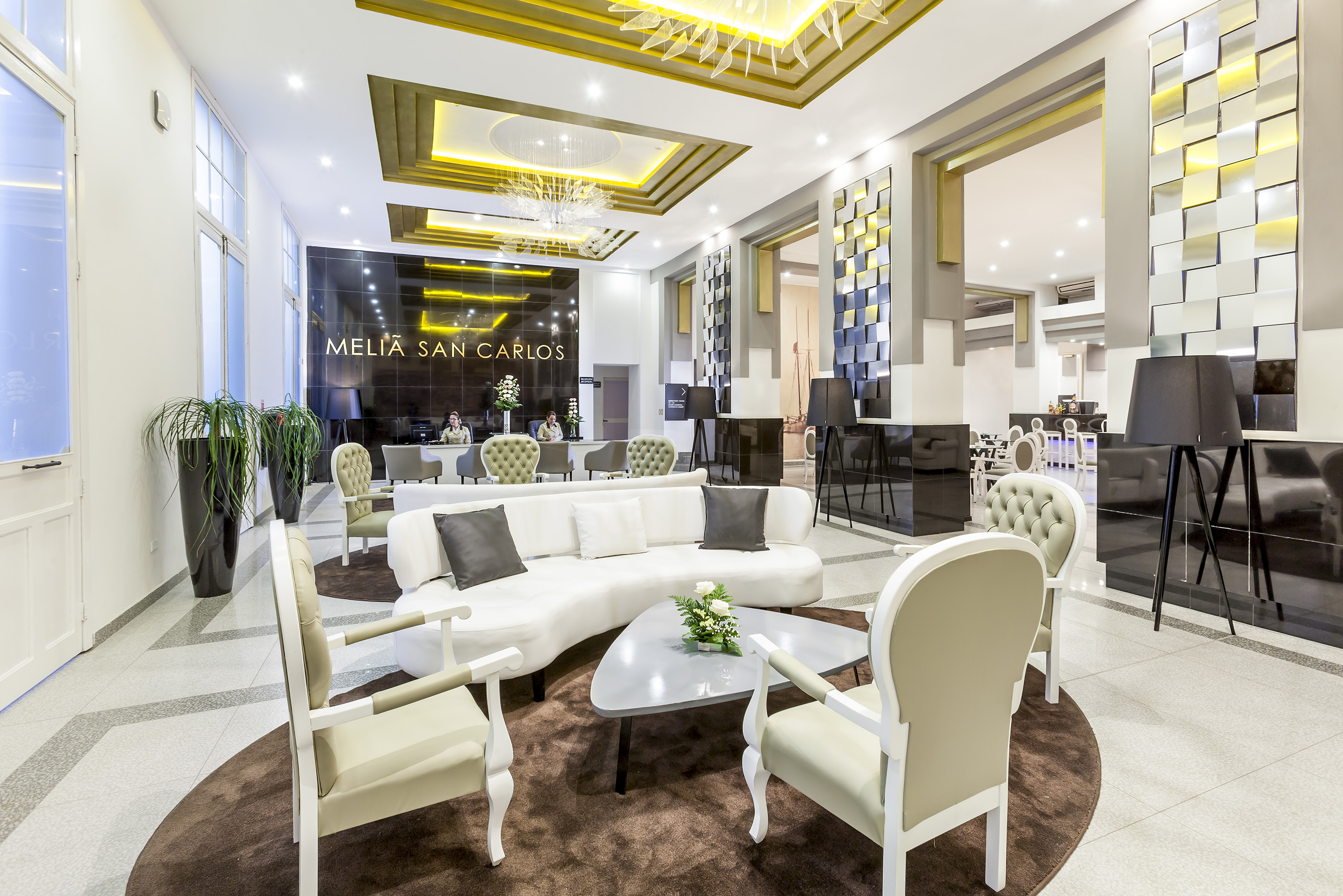 a lobby with a white couch and chairs