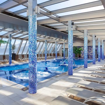 a pool with blue columns and chairs
