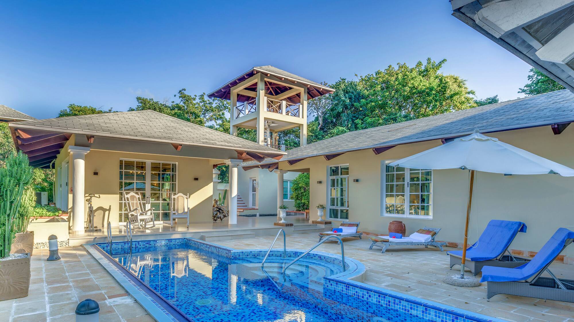 a swimming pool with a white umbrella and a white tower