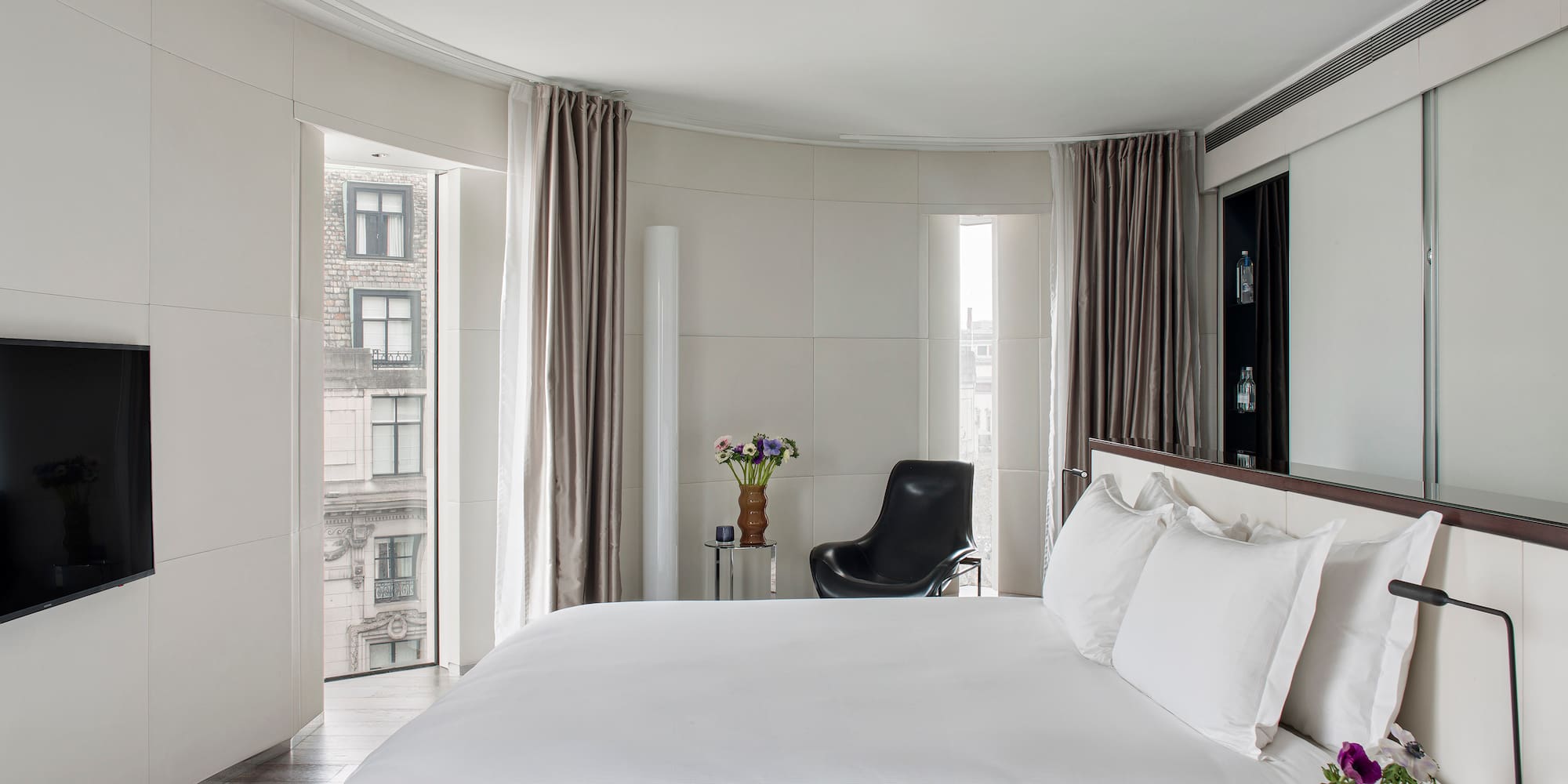 a bedroom with a large bed and a chair