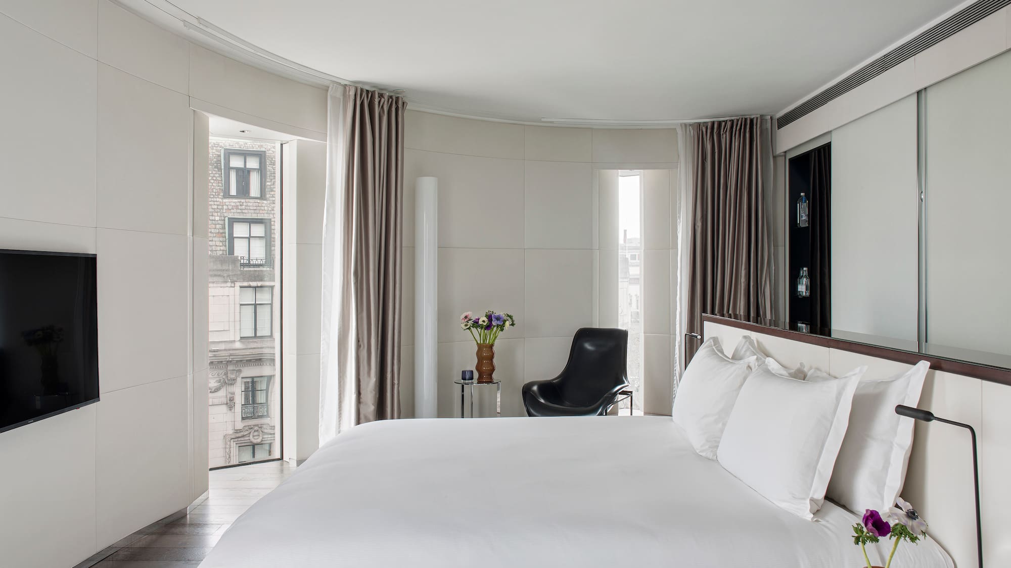 a bedroom with a large bed and a chair