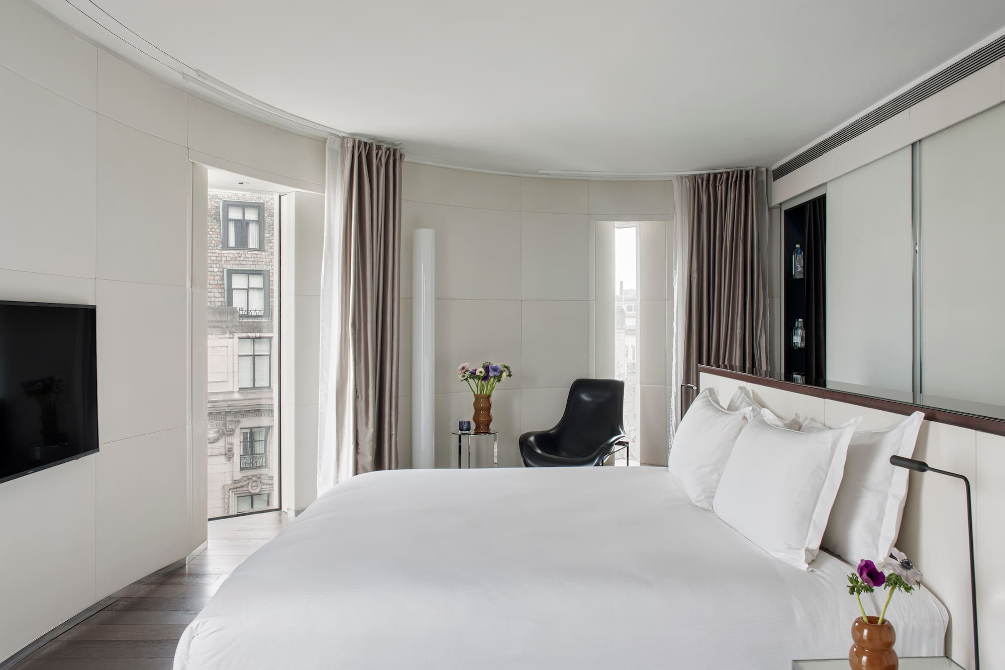 a bedroom with a large bed and a chair