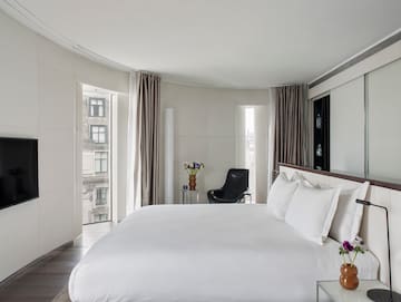 a bedroom with a large bed and a chair