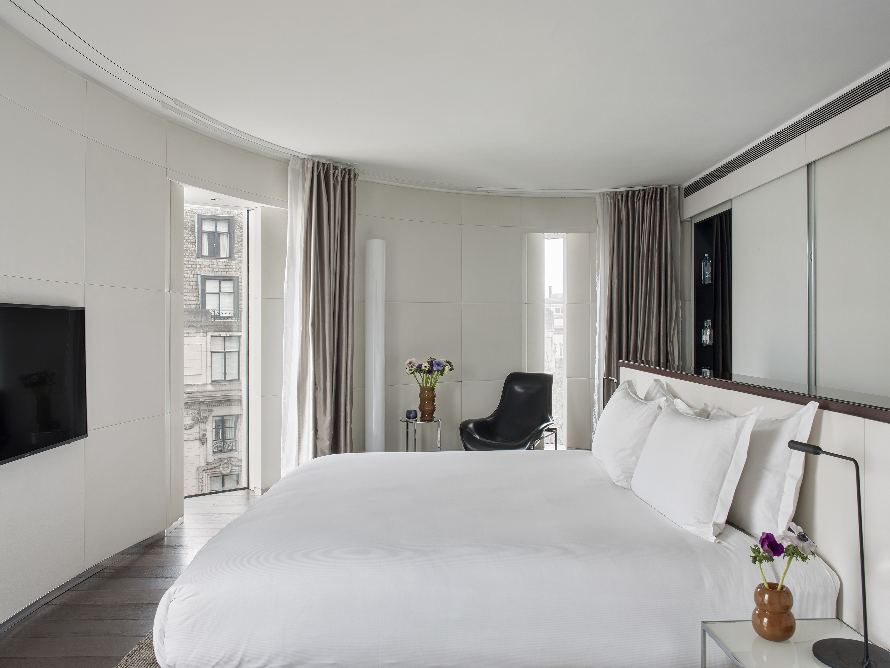 a bedroom with a large bed and a chair