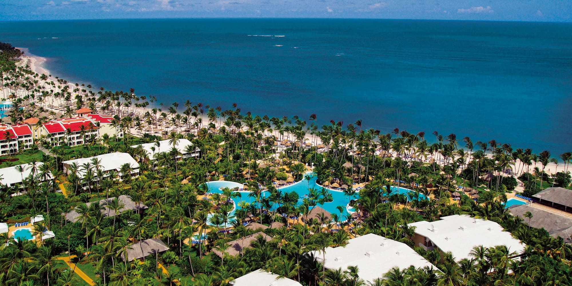 a aerial view of a resort with palm trees and a beach