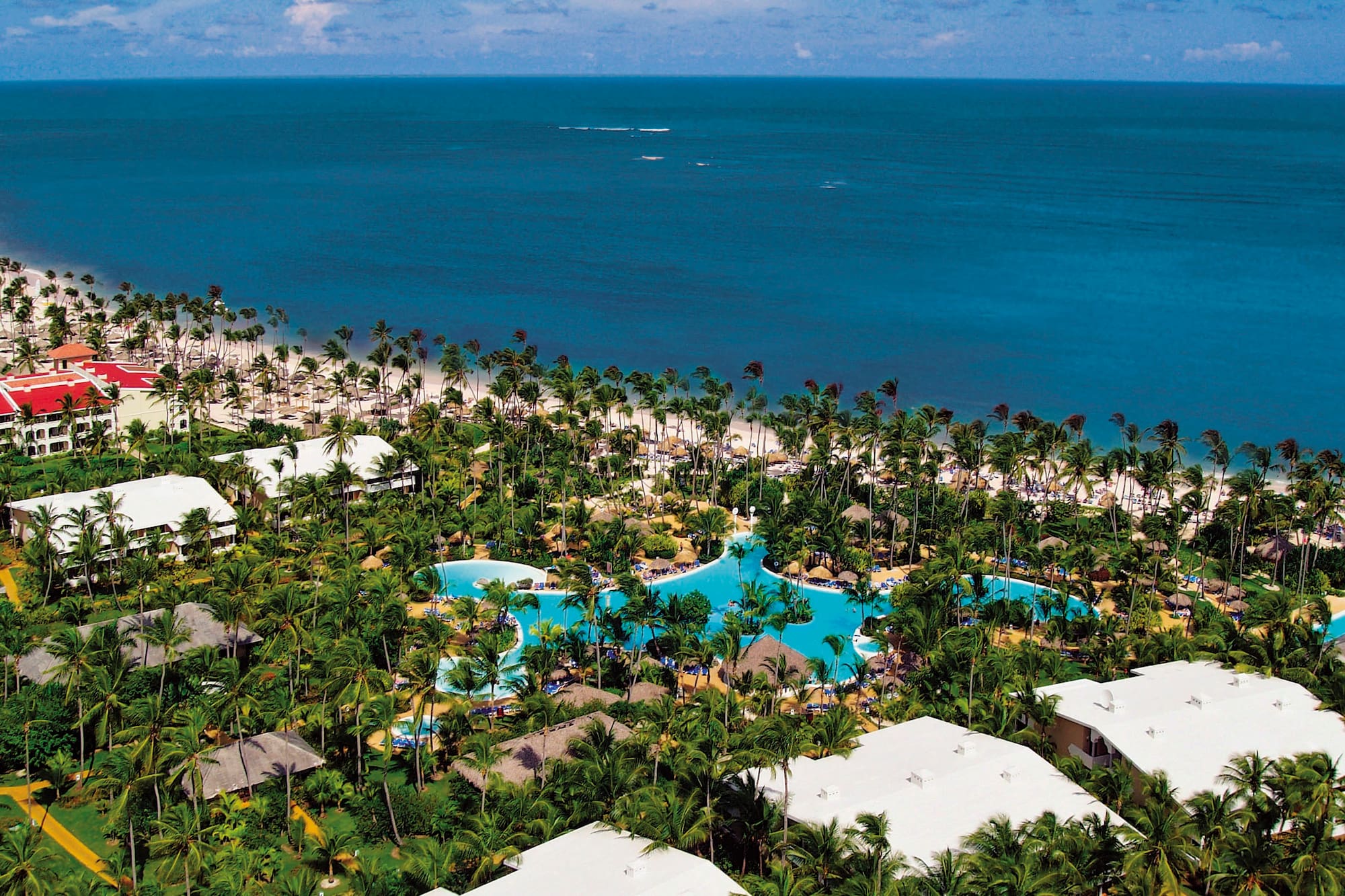 a aerial view of a resort with palm trees and a beach
