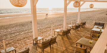 a beach with chairs and tables