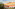 Colorful Mediterranean building with arches, white windows, and olive trees.