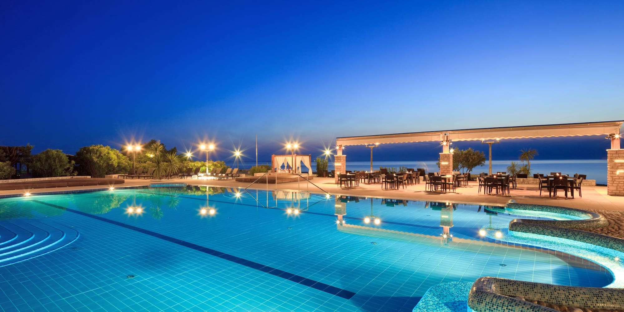 a swimming pool with a gazebo and chairs