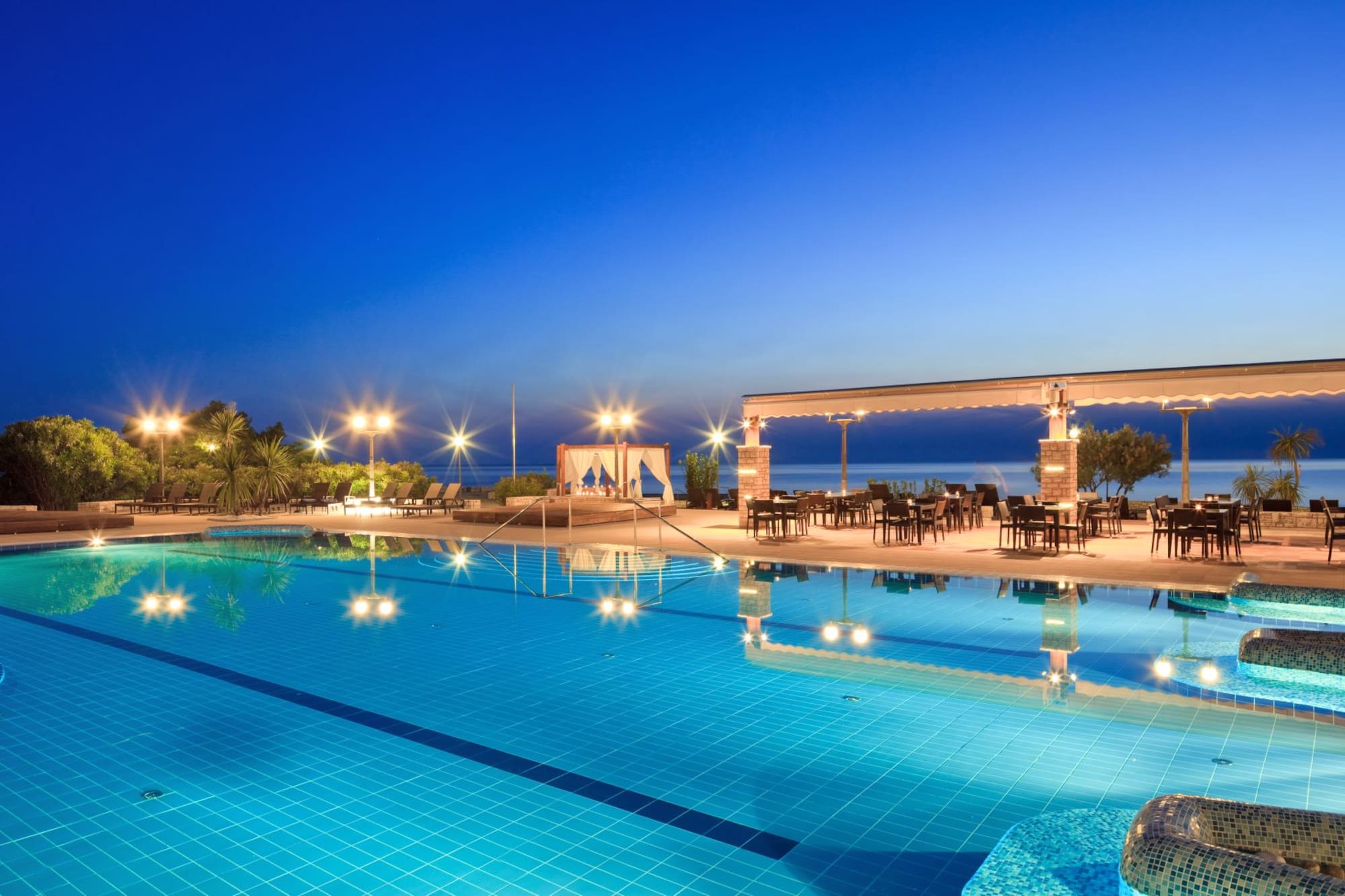 a swimming pool with a gazebo and chairs