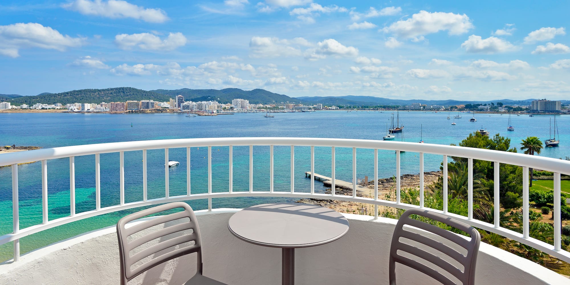 a table and chairs on a balcony overlooking a body of water