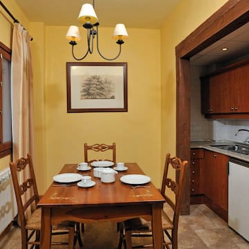 a dining table with plates and chairs in a kitchen