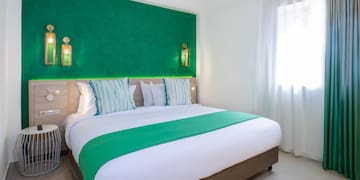 a bed with green and white bedding