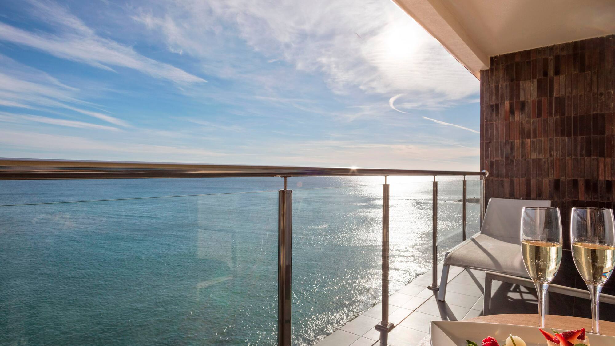 a deck with a table and chairs overlooking the water