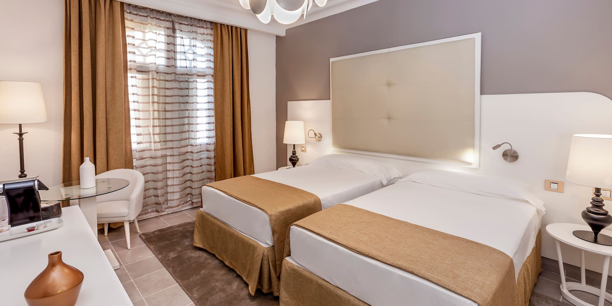 a room with two beds and a lamp