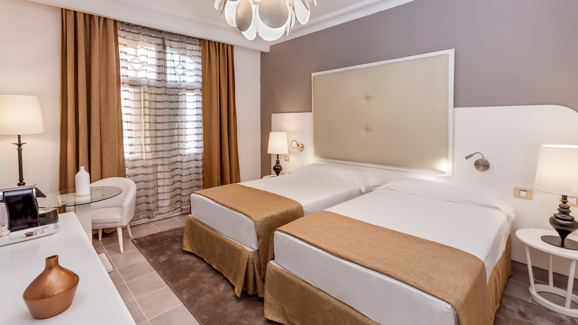 a room with two beds and a lamp