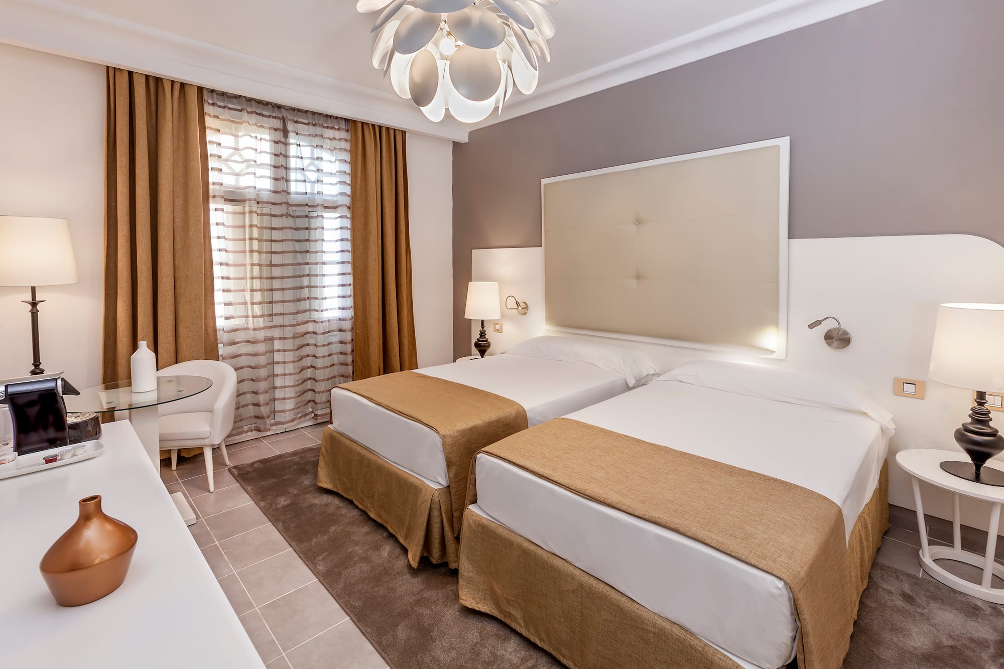 a room with two beds and a lamp