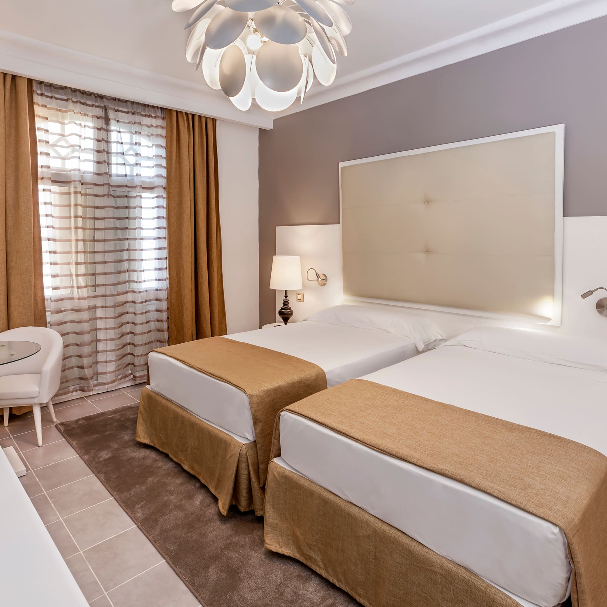 a room with two beds and a lamp