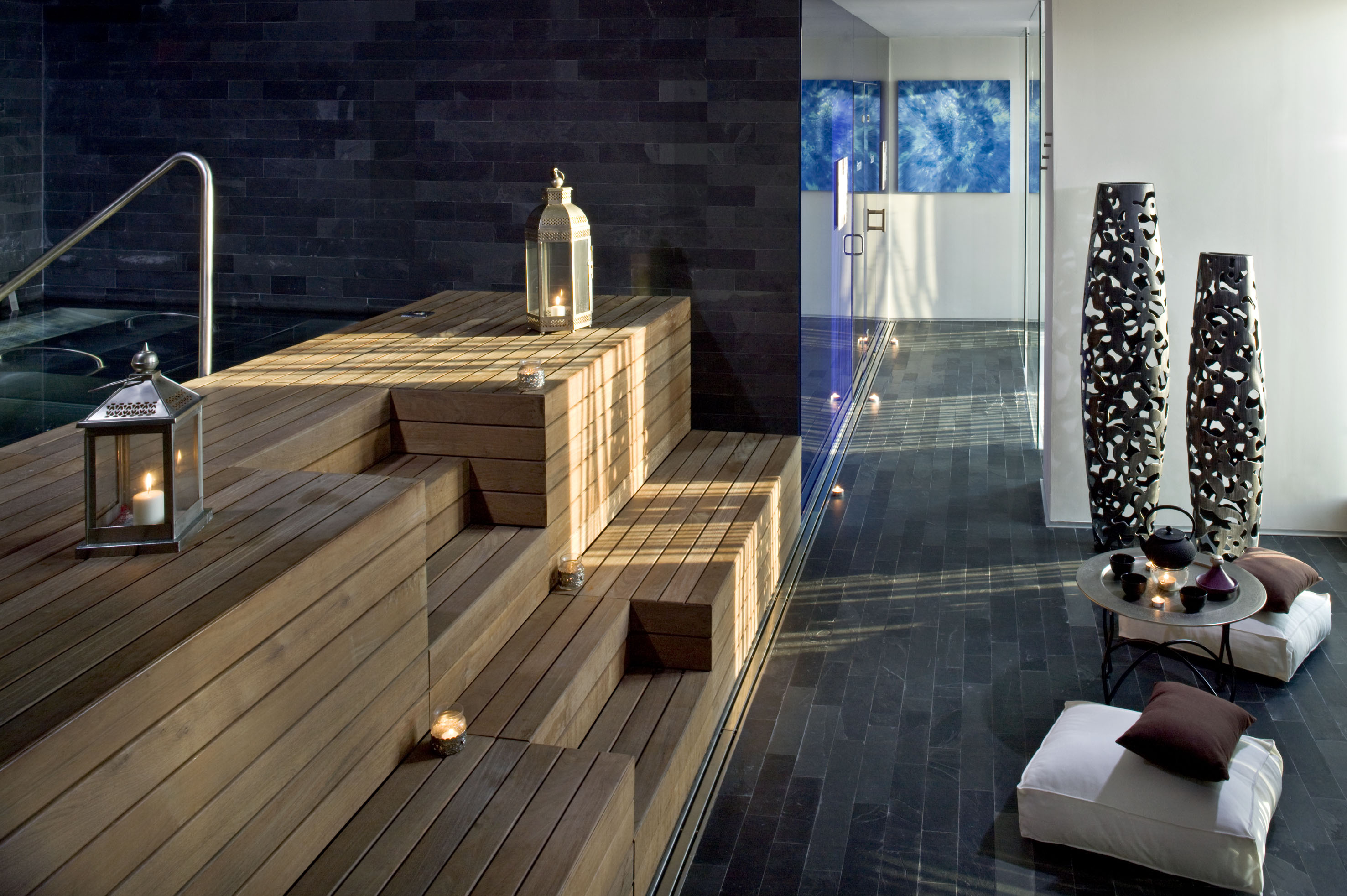 Spa wellness area with wooden deck, ambient lanterns, dark pool, and lounge.
