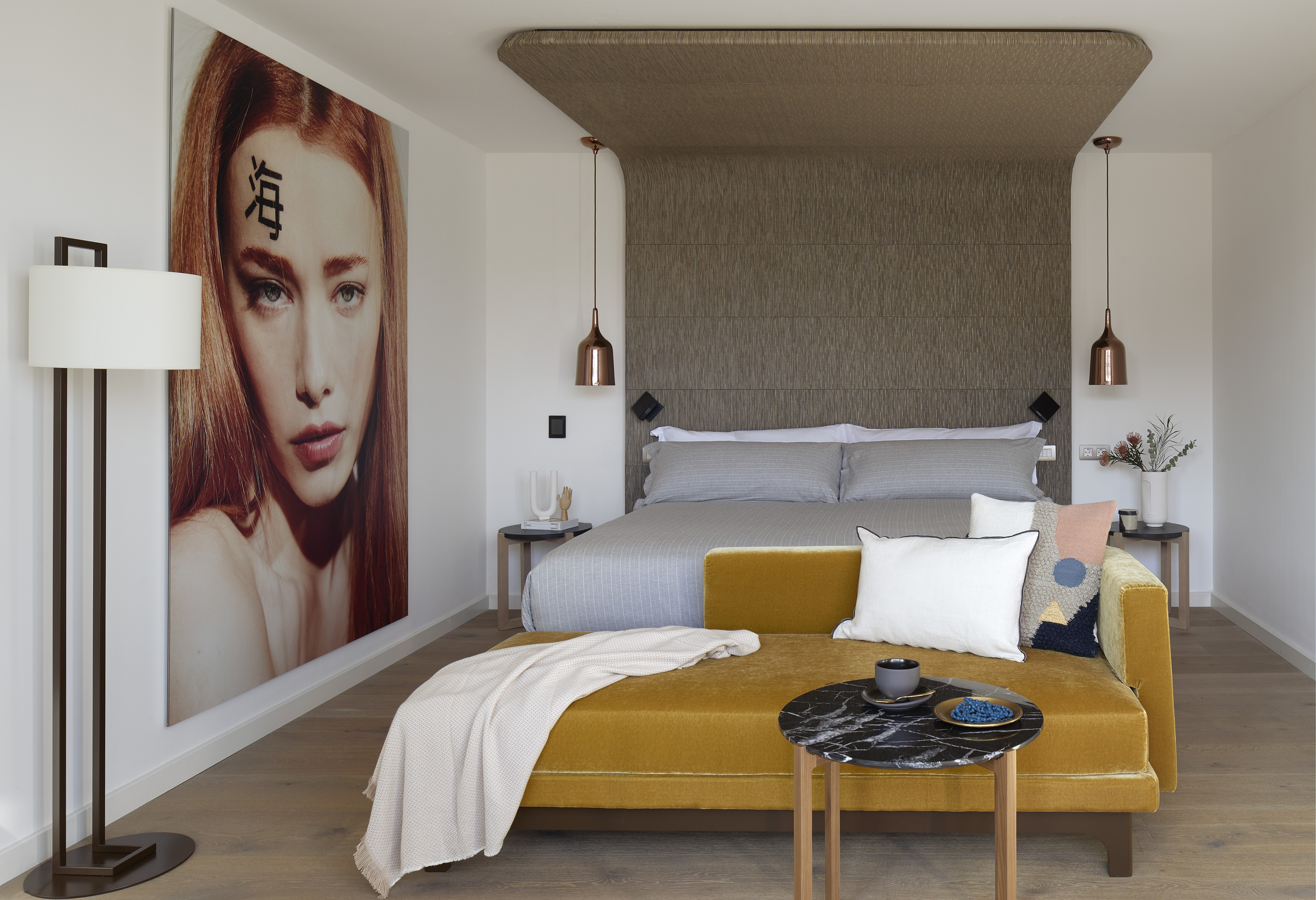 Modern luxury bedroom with velvet chaise, upholstered headboard, and large art.