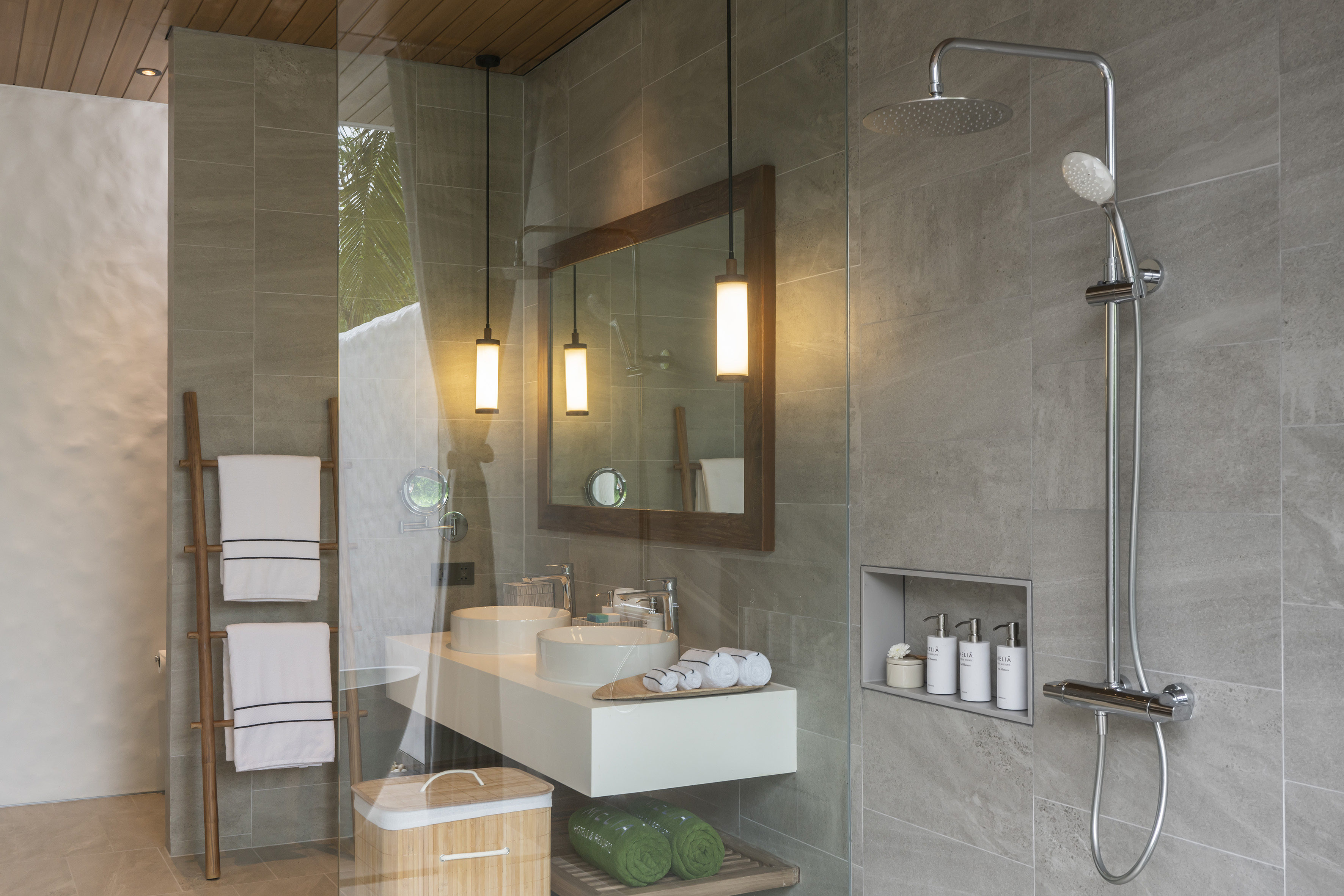 Modern bathroom with dual vanity, rainfall shower, and grey tiled walls.